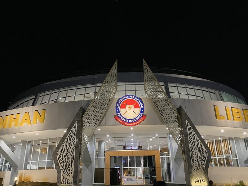 Signage identitas gedung UNHAN Library menyala pada malam hari